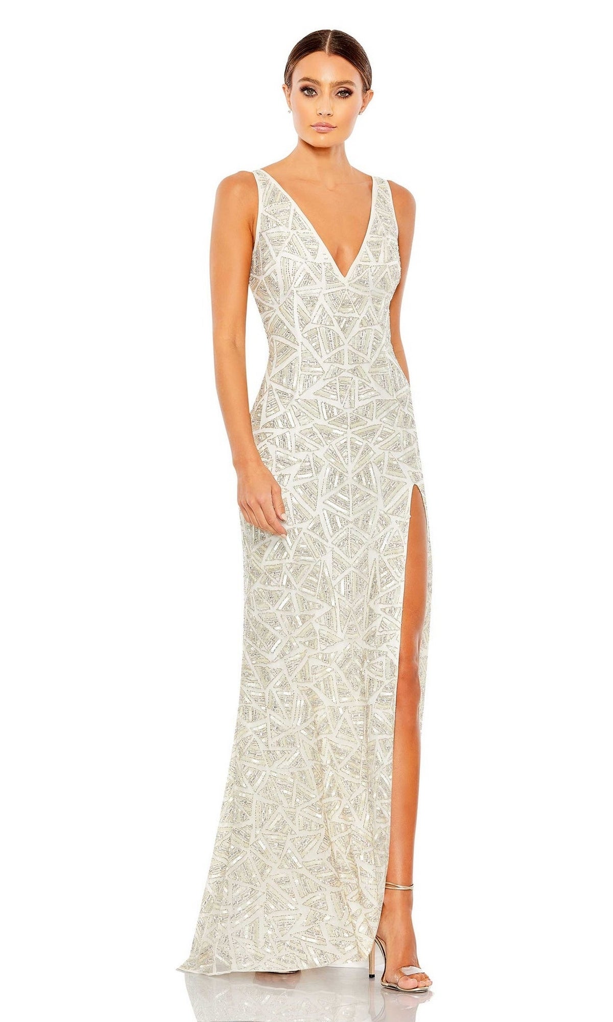 A woman wearing the Long Formal Dress 93552 by Mac Duggal, a sleeveless, floor-length geometric print dress with a V-neckline and thigh-high slit, paired with high-heeled sandals.